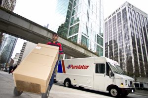 Hand delivery of packages by a Purolator employee in a city