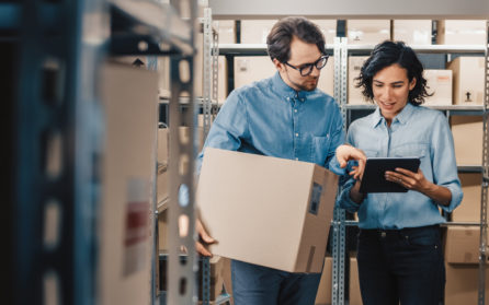 two employees working with boxes and mobile device