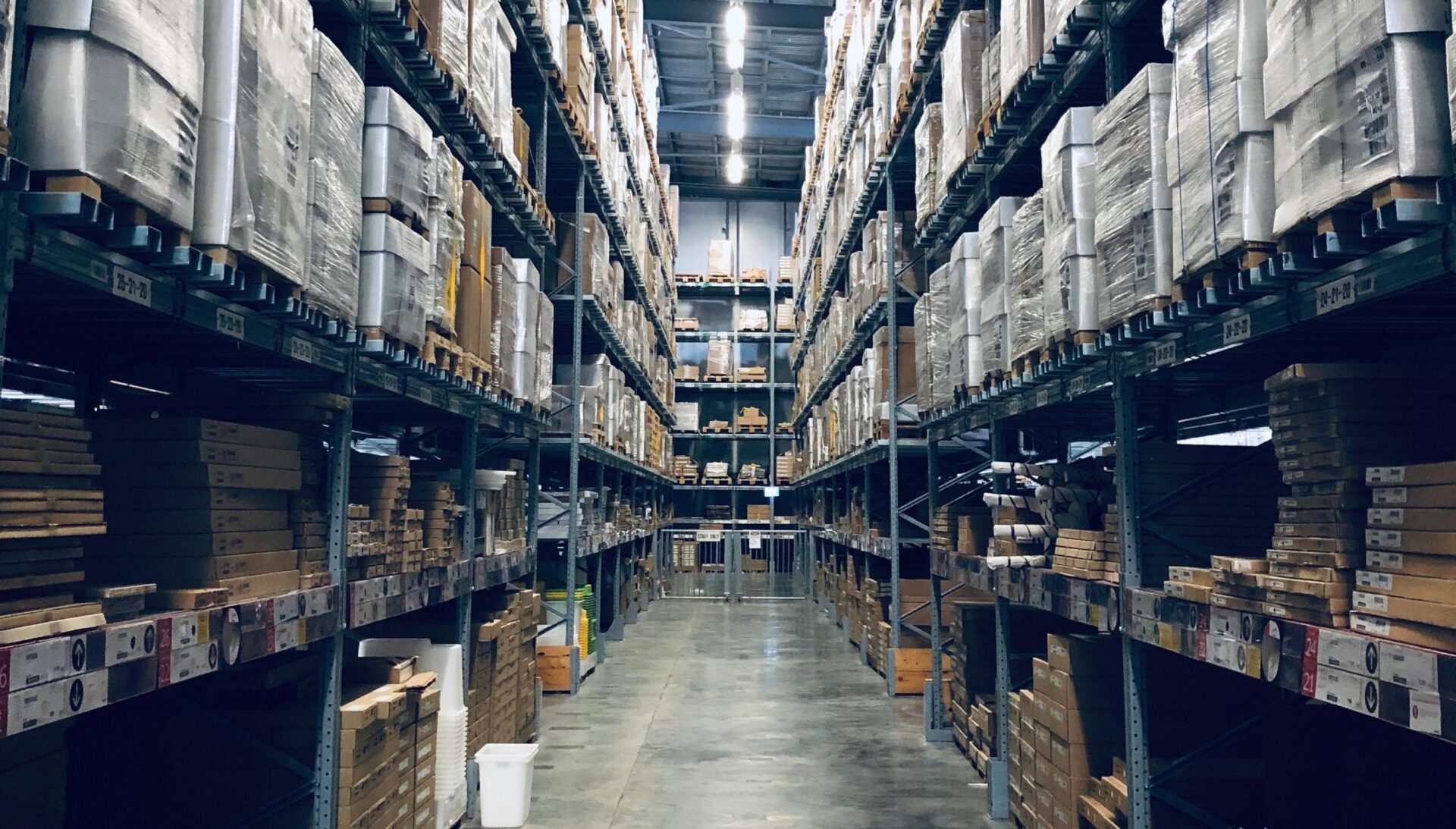 Warehouse aisle with towering shelves full of packages